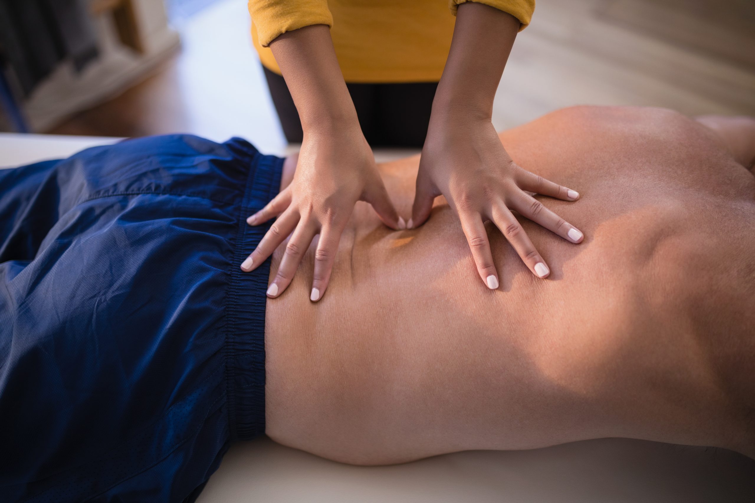 Midsection female therapist giving back massage at East Hills Physiotherapy in Calgary